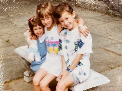 Three sisters sitting on a bench