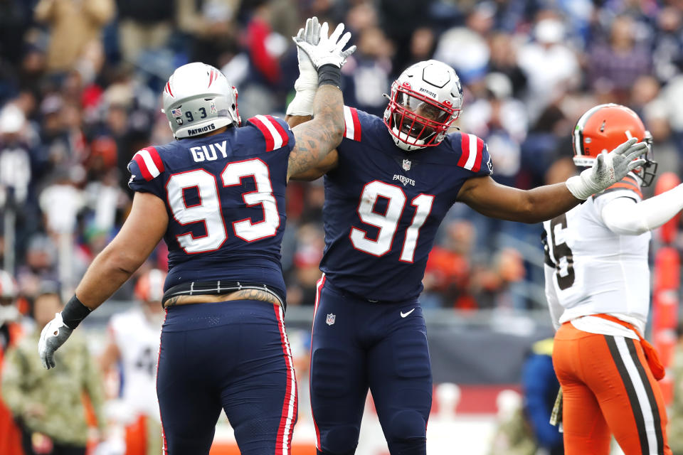 New England Patriots defensive end Deatrich Wise (91) is celebrates with Lawrence Guy (93) during the second half of an NFL football game against the Cleveland Browns, Sunday, Nov. 14, 2021, in Foxborough, Mass. At right is Cleveland Browns quarterback Baker Mayfield (6). (AP Photo/Michael Dwyer)