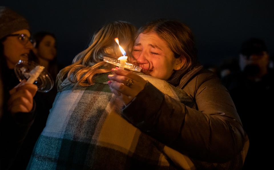A person holding a candle hugs someone at the Clawson City Park during a vigil to honor one of their own, Alexandria "Alex" Verner, along with other MSU shooting victims in Clawson on Tuesday, Feb. 14, 2023.