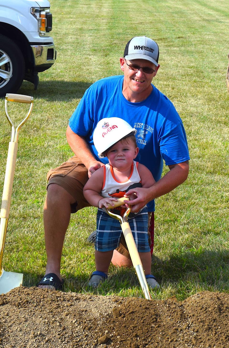 Dan Hendershott helps his two-year-old grandson, Waylon Hendershott, dig dirt at the ceremony celebrating the opening of the new West Holmes Elementary School behind West Holmes Middle School and High School.