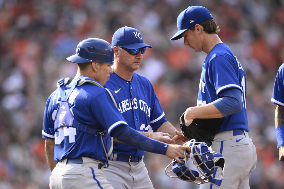 Kansas City Royals manager Matt Quatraro, center, pulls starting pitcher Brady Singer, right, from a baseball game during the fifth inning against the Baltimore Orioles, Saturday, June 10, 2023, in Baltimore. Royals catcher Freddy Fermin, left, looks on. (AP Photo/Nick Wass)