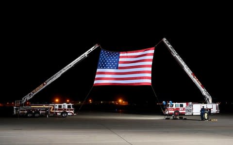 A large US flag is set up ahead of the arrival of US detainees  - Credit:  AFP