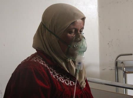 A woman, affected by what activists say was a gas attack, breathes through an oxygen mask inside a field hospital in Kfar Zeita village in the central province of Hama April 12, 2014. REUTERS/Stringer/Files