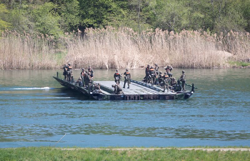 Soldiers of the Swiss Army stand on a ponton during an exercise river near Doettingen