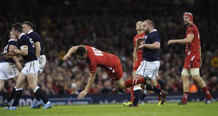 Wales' Dan Biggar is hit by Scotland's Stuart Hogg (L), who was subsequently sent off for his bad tackle, during their Six Nations Championship rugby union match at the Millennium Stadium in Cardiff, Wales March 15, 2014. REUTERS/Rebecca Naden