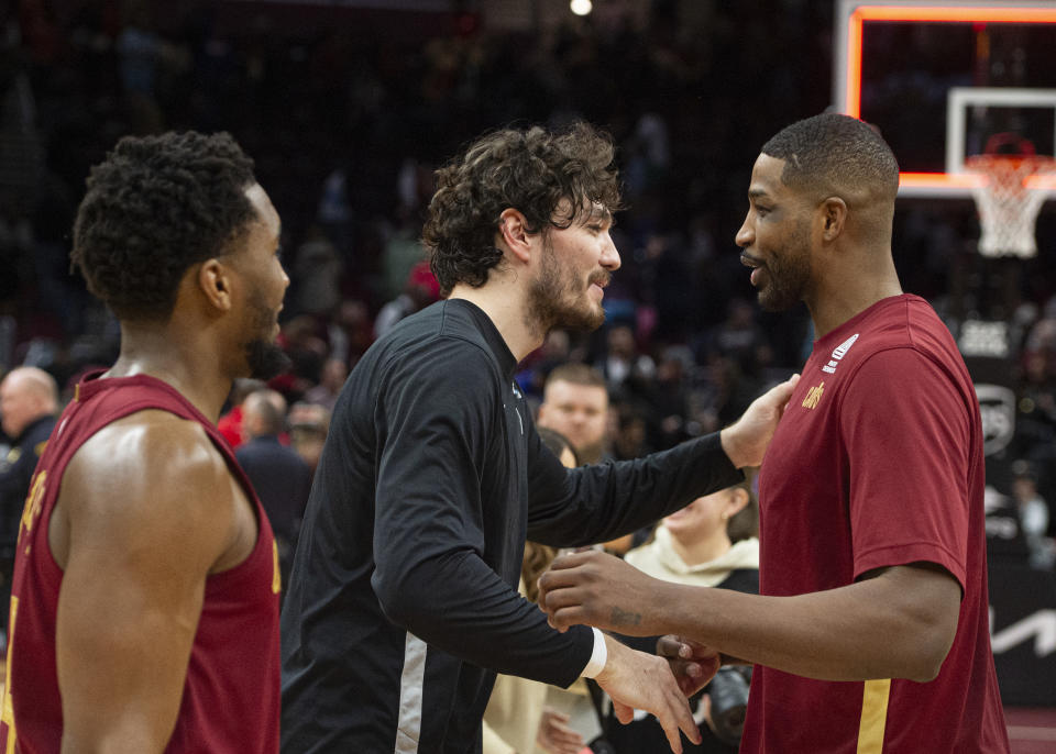 San Antonio Spurs' Cedi Osman, center, is greeted by Cleveland Cavaliers' Tristan Thompson, right, as Cleveland's Donovan Mitchell looks on, left, after an NBA basketball game in Cleveland, Sunday, Jan. 7, 2024. (AP Photo/Phil Long)