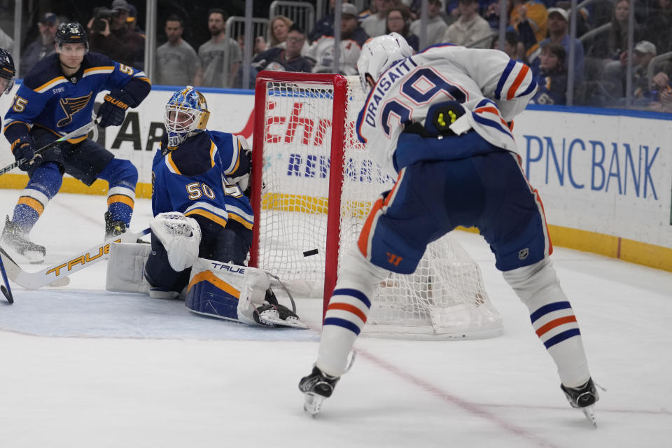 Edmonton Oilers' Leon Draisaitl (29) scores past St. Louis Blues goaltender Jordan Binnington (50) during the third period of an NHL hockey game Monday, April 1, 2024, in St. Louis. (AP Photo/Jeff Roberson)