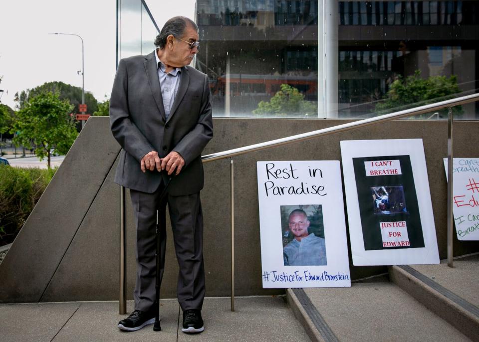 A man in a suit looking down at posters on an outdoor stairway