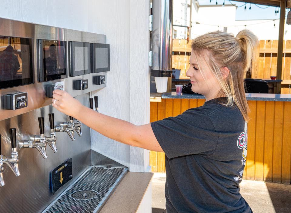 Pickerington resident Chelsie Mitchell uses the self-pour beverage wall at Cardo's Pizza & Tavern on June 27.