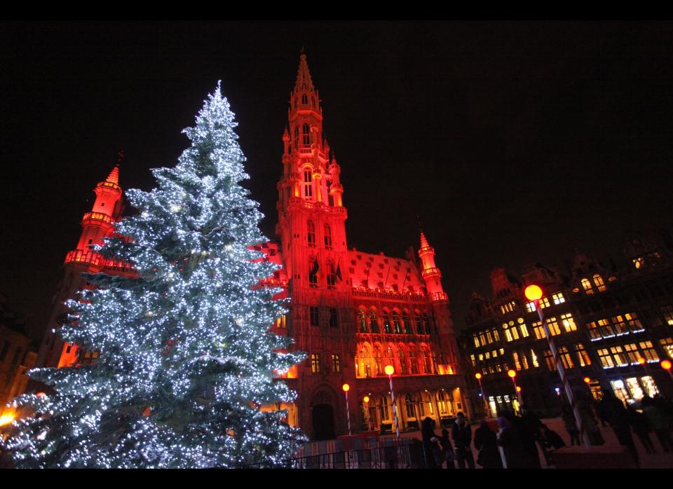 Twinkling blue lights illuminate a tree in front of Brussels' Town Hall at La Grande Place. 