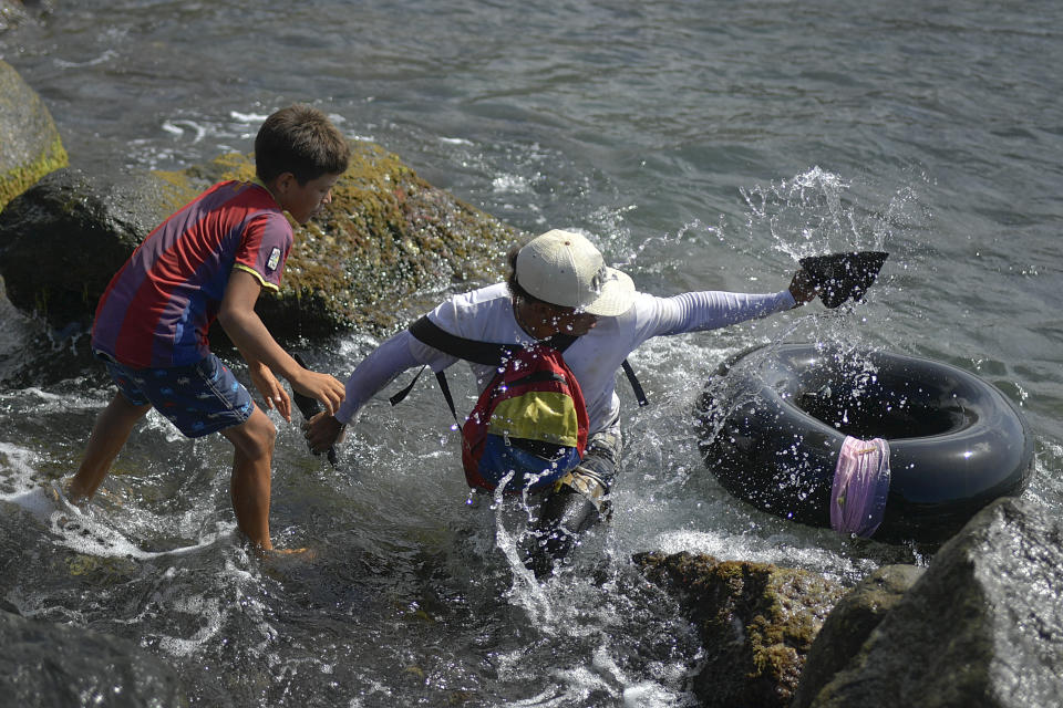 Jonny Gómez, un albañil de oficio y 22 años de edad, regresa a la costa después de pasar un día pescando en mar abierto en su cámara neumática, en Playa Escondida, en La Guaira, Venezuela, el viernes 14 de agosto de 2020. Gómez y otros que reman en pequeños grupos para desafiar al mar y ganarse la vida, perdieron sus trabajos en restaurantes o tiendas que atienden a los bañistas debido al confinamiento por la pandemia de COVID-19. (Foto AP/Matias Delacroix)