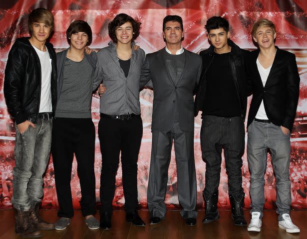 <p>Dave Hogan/Getty</p> One Direction with Simon Cowell on The X Factor