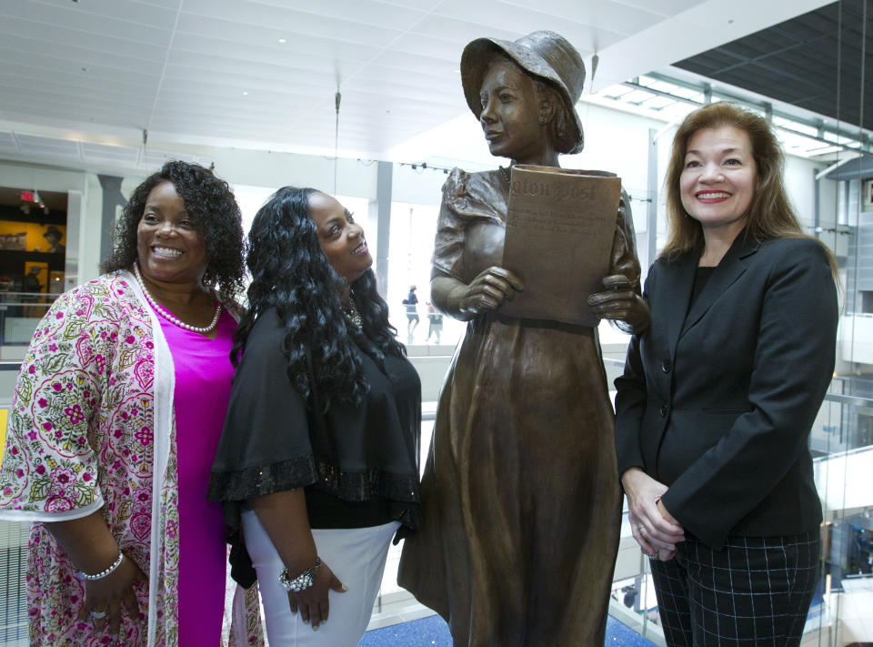 From left, Penny Allison Lockhart and Angela Alice Stephens, great nieces of Alice Allison Dunnigan, stand with sculpture artist Amanda Matthews during the unveiling of Dunnigan's statue at the Newseum, Friday, Sept. 21, 2018, in Washington. Dunnigan triumphed over sexism and racism to become the first black woman accredited to cover the White House. (AP Photo/Jose Luis Magana)