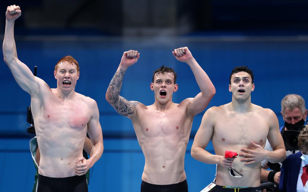 Tom Dean, James Guy and Matthew Richards of Team Great Britain react as teammate Duncan Scott (not pictured) swims the anchor leg during the Men's 4 x 200m Freestyle Relay Final on day five of the Tokyo 2020 Olympic Games at Tokyo Aquatics Centre on July 28, 2021 in Tokyo, Japan. - GETTY IMAGES