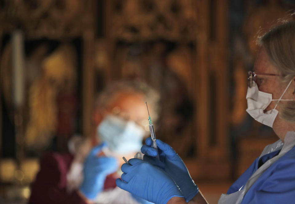 Health workers prepare the Pfizer-BioNTech vaccine inside Salisbury Cathedral in Salisbury, England, Wednesday, Jan. 20, 2021. Salisbury Cathedral opened its doors for the second time as a venue for the Sarum South Primary Care Network COVID-19 Local Vaccination Service. (AP Photo/Frank Augstein)