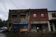A person stands outside as storm clouds start to rain on Friday, Aug. 5, 2022, in Fleming-Neon, Ky. (AP Photo/Brynn Anderson)
