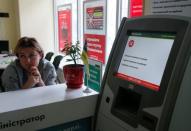 An employee sits next to a payment terminal out of order at a branch of Ukraine's state-owned bank Oschadbank after Ukrainian institutions were hit by a wave of cyber attacks earlier in the day, in Kiev, Ukraine, June 27, 2017. REUTERS/Valentyn Ogirenko