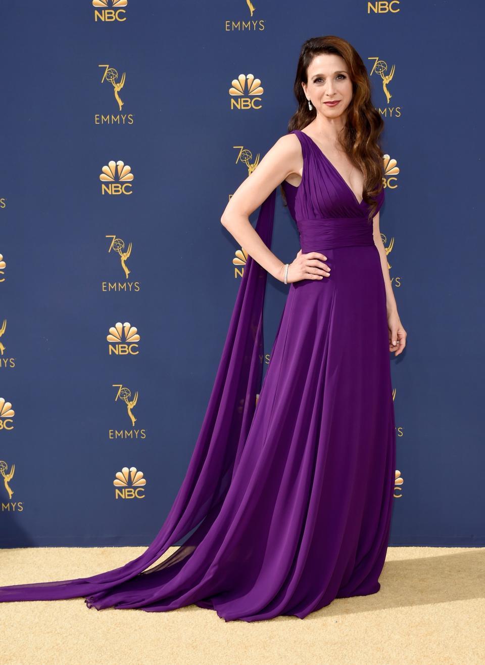 <p>You would never guess that this was fashion stylist Micah Schifman's first time working with <em><a rel="nofollow noopener" href="https://www.townandcountrymag.com/leisure/arts-and-culture/a16723931/the-marvelous-mrs-maisel-season-2/" target="_blank" data-ylk="slk:Marvelous Mrs. Maisel;elm:context_link;itc:0;sec:content-canvas" class="link ">Marvelous Mrs. Maisel</a></em> star Marin Hinkle: their energy makes it seem like they've known each other forever. Schifman, who's worked with A-list celebrities like Diane Kruger and Sarah Silverman, shared that the month-and-a-half long process of creating Hinkle's Emmy Awards look resulted in exactly what the two had envisioned from day one - every stylist’s dream come true.</p><p>Hinkle stepped out onto the 2018 Emmy Awards golden carpet wearing a vibrant custom-made violet dress. The tulle and chiffon gown was designed by Oliver Tolentino, a local Los Angeles talent that Hinkle found. Dramatic <a rel="nofollow noopener" href="https://www.normansilverman.com/" target="_blank" data-ylk="slk:Norman Silverman;elm:context_link;itc:0;sec:content-canvas" class="link ">Norman Silverman</a> diamonds, strappy <a rel="nofollow noopener" href="https://www.stuartweitzman.com/home/" target="_blank" data-ylk="slk:Stuart Weitzman;elm:context_link;itc:0;sec:content-canvas" class="link ">Stuart Weitzman</a> heels, and an embellished <a rel="nofollow noopener" href="https://www.swarovski.com/en-US/" target="_blank" data-ylk="slk:Swarovski;elm:context_link;itc:0;sec:content-canvas" class="link ">Swarovski</a> clutch added the finishing touches to Hinkle’s look. </p><p>Get a behind-the-scenes look at Schifman and Hinkle's process here:</p>