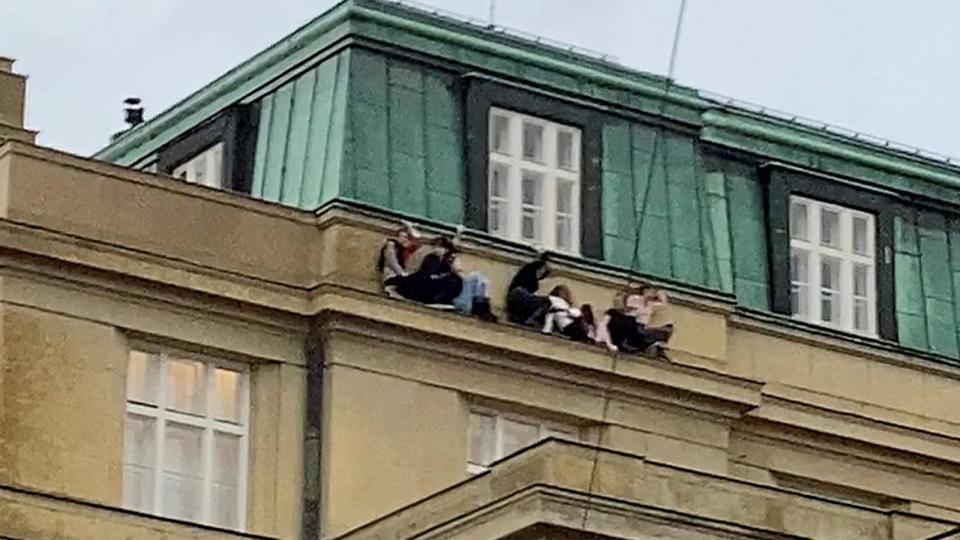 PHOTO: People sit on a ledge during a shooting at one of the buildings of Charles University, in Prague, Czech Republic, Dec. 21, 2023. (Ivo Havranek via Reuters)
