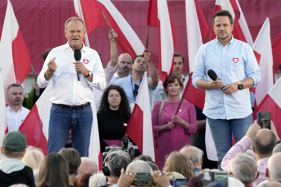 Poland's opposition leader and former prime minister, Donald Tusk, left, and his Civic Platform member, Warsaw Mayor Rafal Trzaskowski, right, stand on stage during an election campaign rally in Otwock, Poland, on Monday, Sept. 25, 2023. (AP Photo/Czarek Sokolowski)