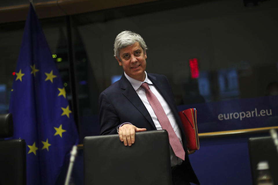 FILE - In this Monday, Nov. 18, 2019 file photo Eurogroup President Mario Centeno arrives to a Committee on Economic and Monetary Affairs at the European Parliament in Brussels. Governments from the 19 countries that use the euro overcame sharp differences to agree Thursday on measures that could provide more than a half-trillion euros ($550 billion) for companies, workers and health systems to cushion the economic impact of the virus outbreak. Mario Centeno, who heads the finance ministers' group from euro countries, called the package of measures agreed upon "totally unprecedented... Tonight Europe has shown it can deliver when the will is there."(AP Photo/Francisco Seco, File)