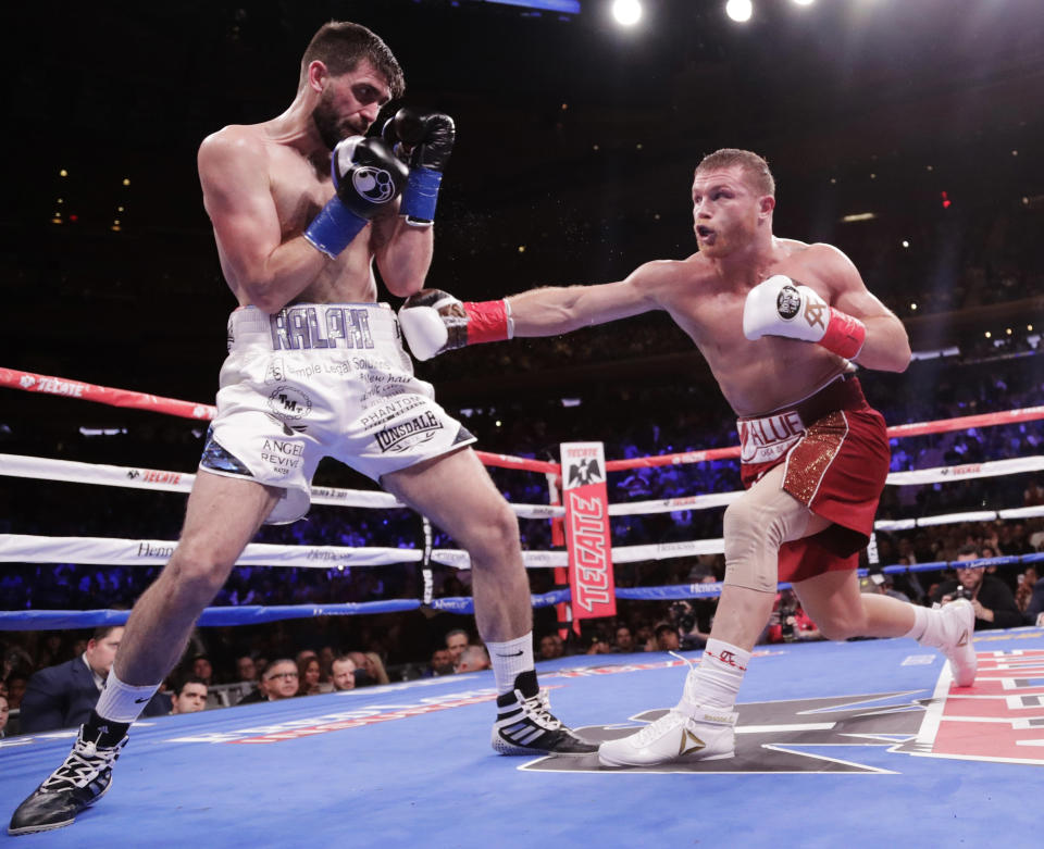Mexico's Canelo Alvarez, right, punches England's Rocky Fielding during the second round of a WBA super middleweight championship boxing match Saturday, Dec. 15, 2018, in New York. Alvarez stopped Fielding in the third round. (AP Photo/Frank Franklin II)