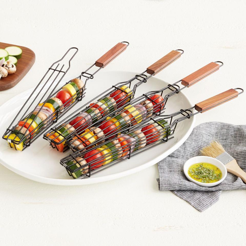 <p><strong>Uncommon Goods </strong></p><p>uncommongoods.com</p><p><strong>$20.00</strong></p><p>No skewer needed: Place zucchini, onions, tomatoes, squash and other seasonal veggies in these wood handled baskets, which make flipping kabobs a breeze. </p>