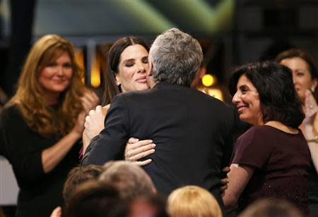 Director Alfonso Cuaron embraces actress Sandra Bullock after he won the award for best director for "Gravity" at the 19th annual Critics' Choice Movie Awards in Santa Monica, California January 16, 2014. REUTERS/Mario Anzuoni