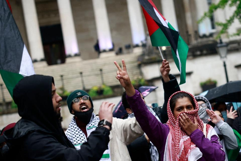 Students waving the Palestinian flag take part in a demonstration in support to Palestinian people at University College London (AFP via Getty Images)