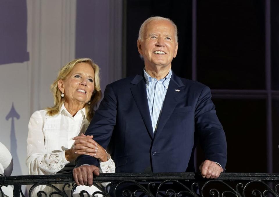 Joe and Jill Biden on the White House balcony.  Jill is clinging to Joe