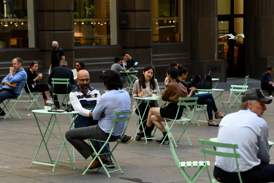 Members of the public sit at outdoors dining areas in the central business district (CBD) of Sydney, Monday. Source: AAP