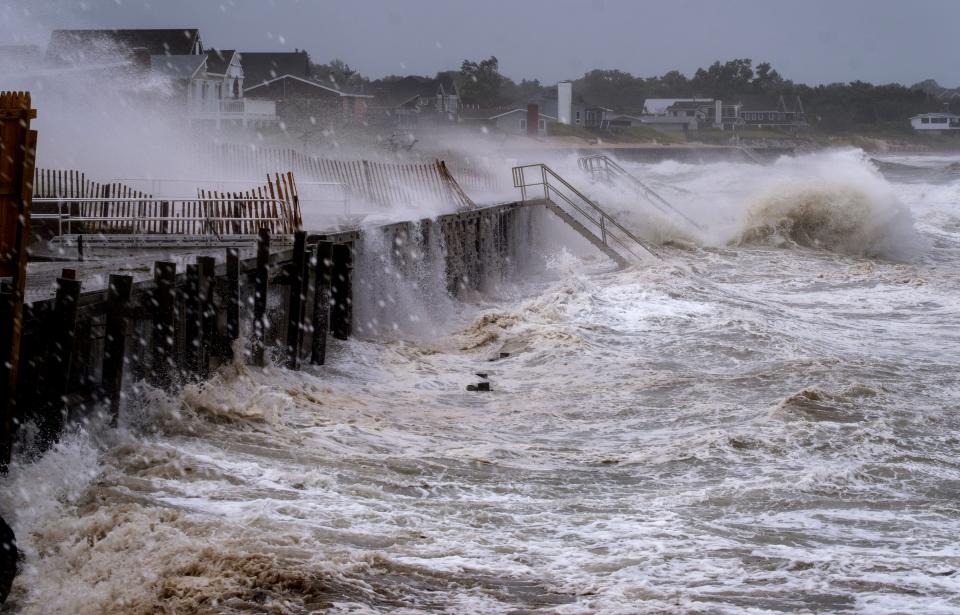 Waves pound a seawall.