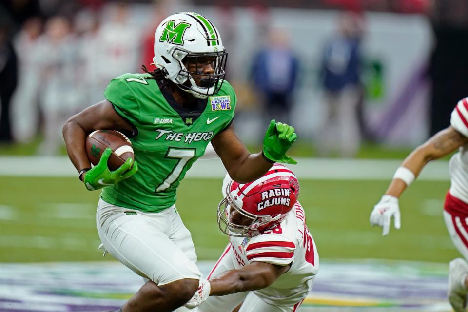 Marshall wide receiver Corey Gammage (7) carries past Louisiana-Lafayette safety Ja'Len Johnson in the first half of the New Orleans Bowl NCAA football game in New Orleans, Saturday, Dec. 18, 2021. (AP Photo/Gerald Herbert)