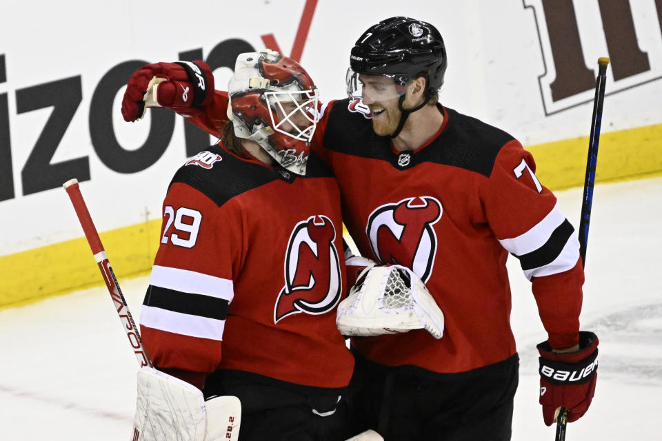 New Jersey Devils goaltender Mackenzie Blackwood (29) and defenseman Dougie Hamilton (7) celebrate after they defeated the Seattle Kraken in an NHL hockey game Thursday, Feb. 9, 2023, in Newark, N.J. (AP Photo/Bill Kostroun)