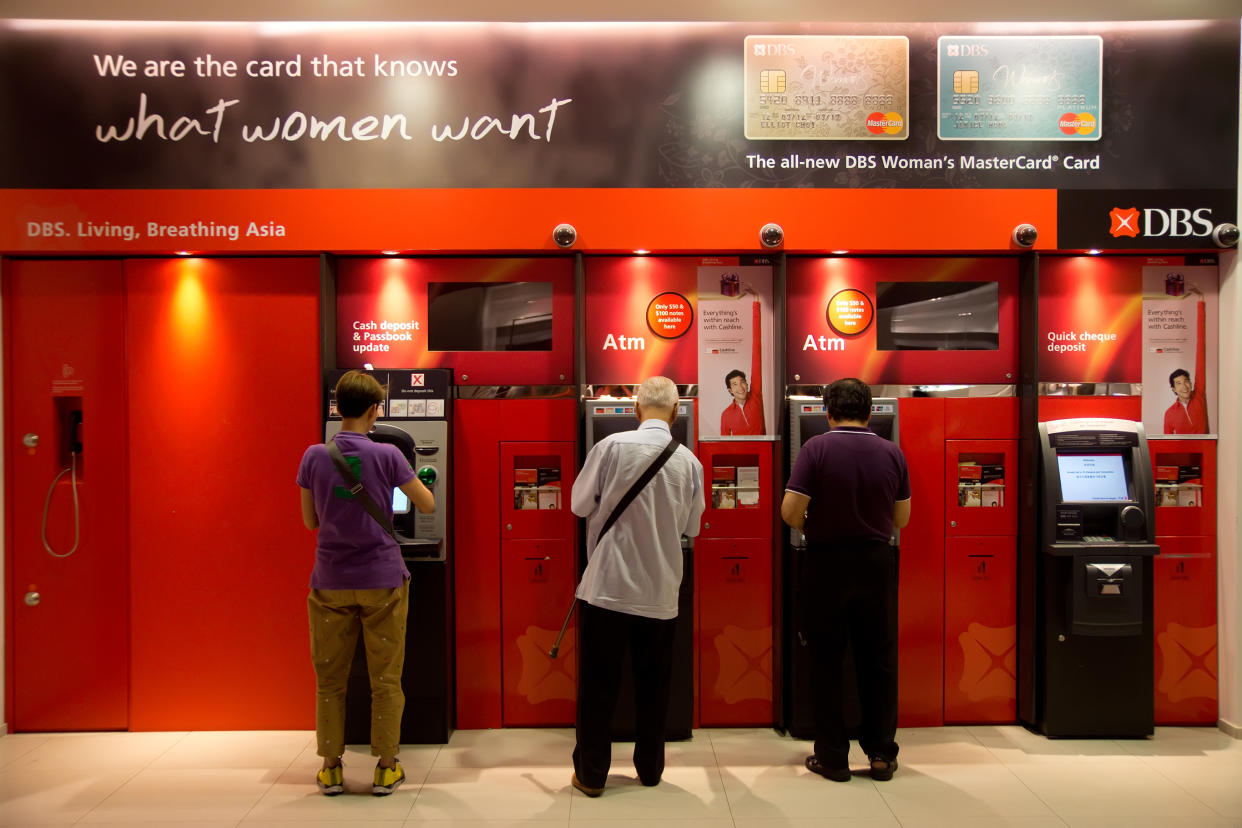 Customers banking money at automated teller machines (ATMs) outside the DBS Bank branch at Marina Bay Sands. (PHOTO: Getty Images)