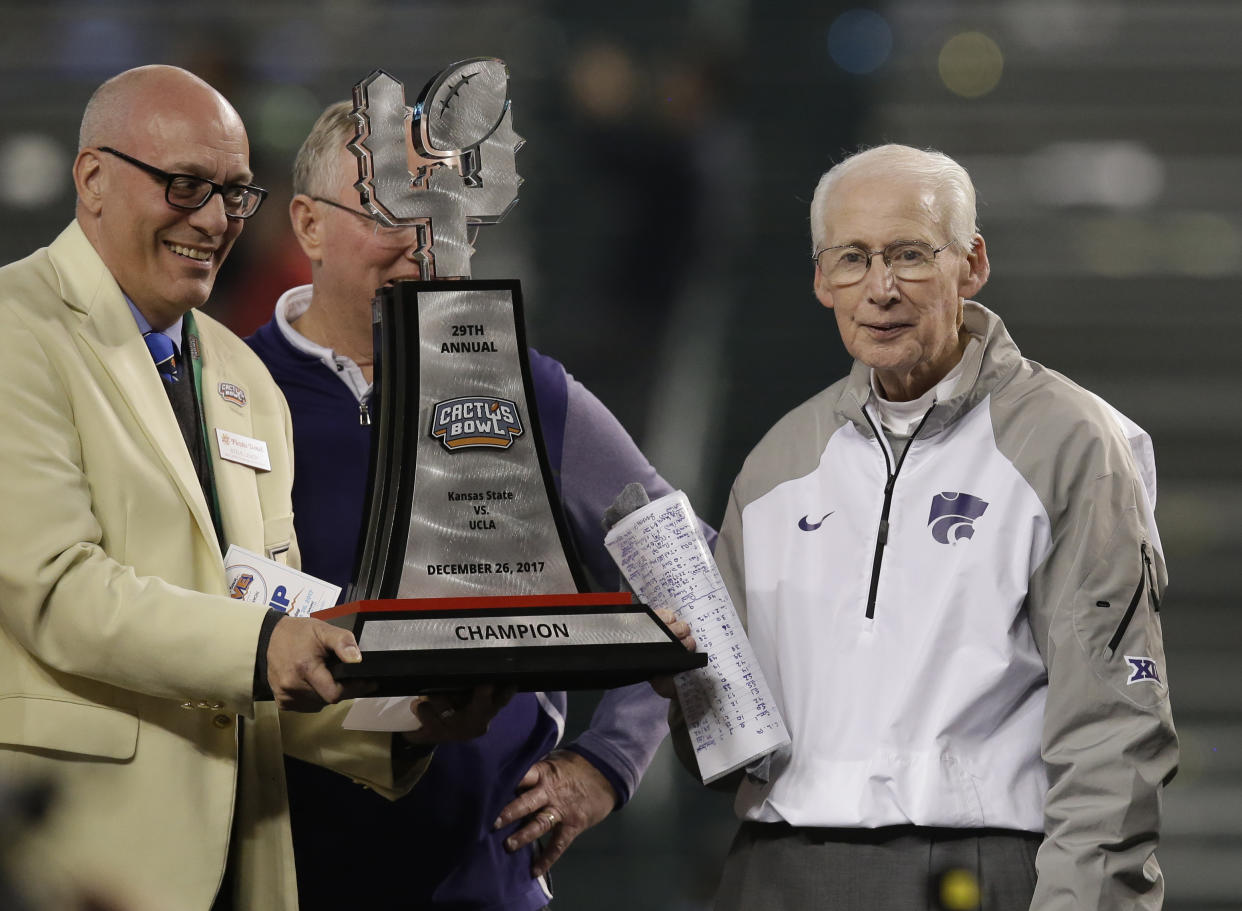 Kansas State head coach Bill Snyder (R) accepts the winning trophy after defeating UCLA 35-17 in the Cactus Bowl last month.(AP)