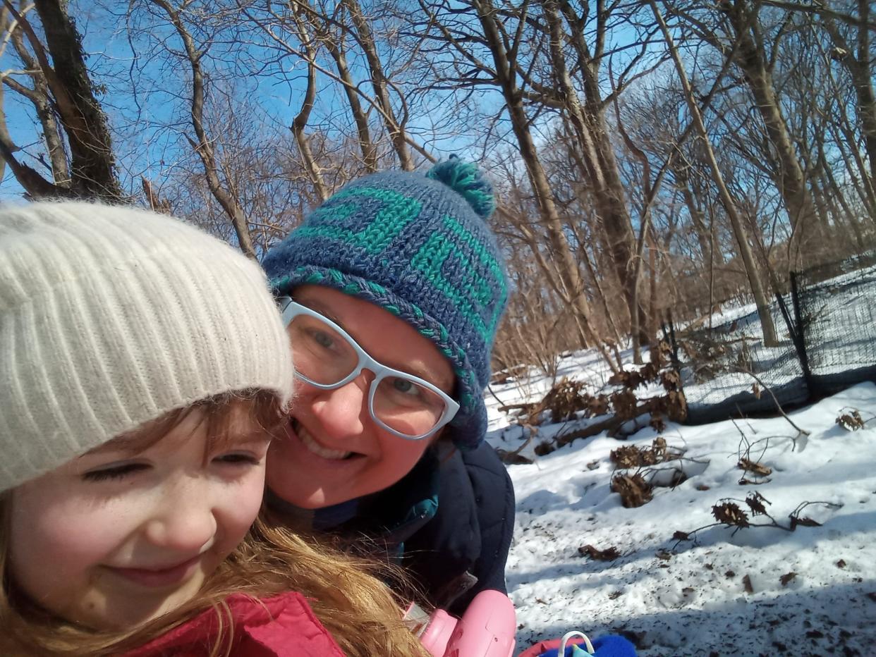 The author pictured with one of her children in a snow-covered forest.