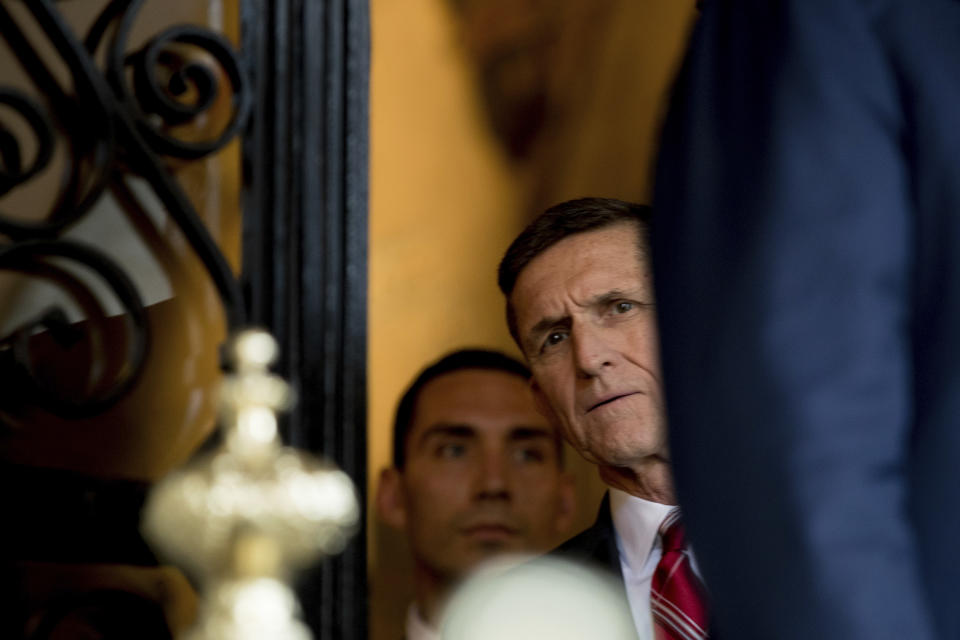 FILE - In this Dec. 21, 2016, file photo, retired Gen. Michael Flynn, a senior adviser to then-President-elect Donald Trump listens as Trump speaks to members of the media at Mar-a-Lago, in Palm Beach, Fla. (AP Photo/Andrew Harnik, File)