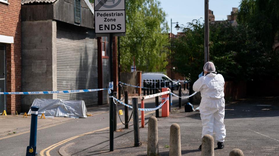 Forensic officer inspect the scene of a fatal stabbing in Boston