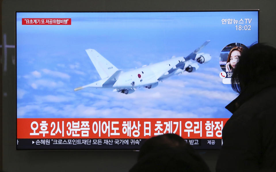 People watch a TV screen showing file footage of a Japanese patrol plane during a news program at the Seoul Railway Station in Seoul, South Korea, Wednesday, Jan. 23, 2019. South Korea's military accused Japan of a "clear provocation" over what it said was a threatening low-altitude flight by a Japanese patrol plane over a South Korean warship on Wednesday. The Korean letters on the screen read: "At 2:03 p.m., a Japanese patrol plane flew close to a South Korea's warship." (AP Photo/Ahn Young-joon)