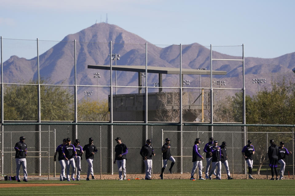 Colorado Rockies players warm up during the team's spring training baseball workout in Scottsdale, Ariz., Wednesday, Feb. 24, 2021. (AP Photo/Jae C. Hong)