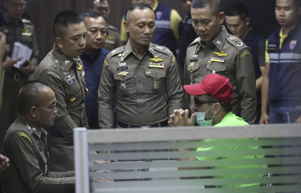 Immigration officials talk to Richard Stanislaus, right, during an interview at the Immigration office in Bangkok, Thailand Tuesday, Oct. 22, 2019. Police in Thailand say they are investigating the death of an elderly German woman Margund Schaefer after arresting Stanislaus, also German, for allegedly dumping her body into a canal. (AP Photo/Sakchai Lalit)