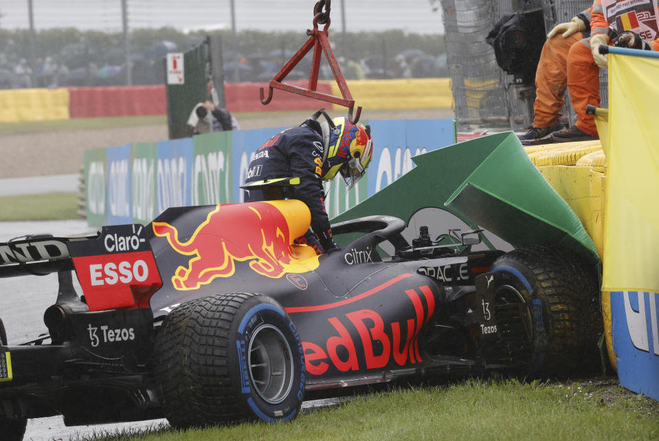 Red Bull driver Sergio Perez of Mexico gets out of his car after crashing on his way to the grid during the Formula One Grand Prix at the Spa-Francorchamps racetrack in Spa, Belgium, Sunday, Aug. 29, 2021. (AP Photo/Olivier Matthys)