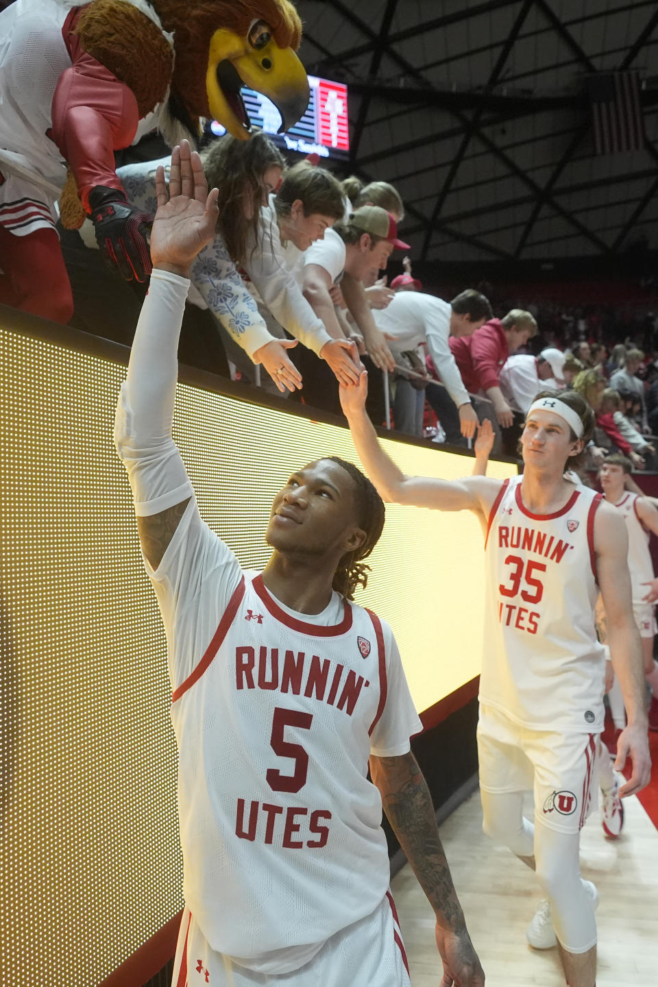 Utah guard Deivon Smith (5) celebrates with fans following an NCAA college basketball game against Colorado, Saturday, Feb. 3, 2024, in Salt Lake City. (AP Photo/Rick Bowmer)