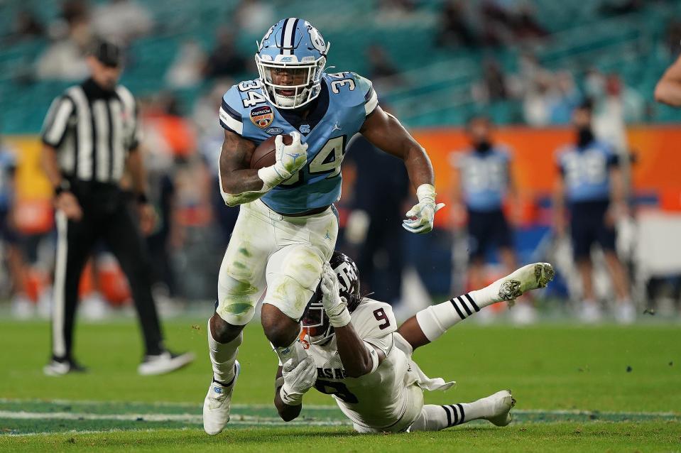 North Carolina running back British Brooks tries to elude the grasp of Texas A&M defensive back Leon O’Neal Jr. during the Orange Bowl game in January.