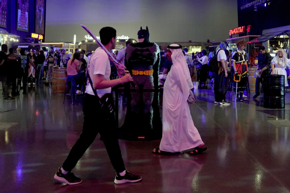 An Emirati man passes by a Batman character during the Dubai Esports and Games Festival in Dubai, United Arab Emirates, Saturday, June 24, 2023. Saudi Arabia, the new home of some of soccer’s biggest stars and a co-owner of professional golf, is proving to be no less ambitious when it comes to another global pastime, the $180 billion-a-year video game industry. (AP Photo/Kamran Jebreili)