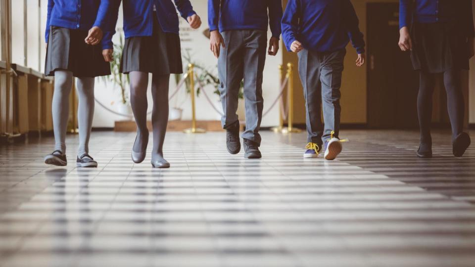 Group of students walking through school hallway