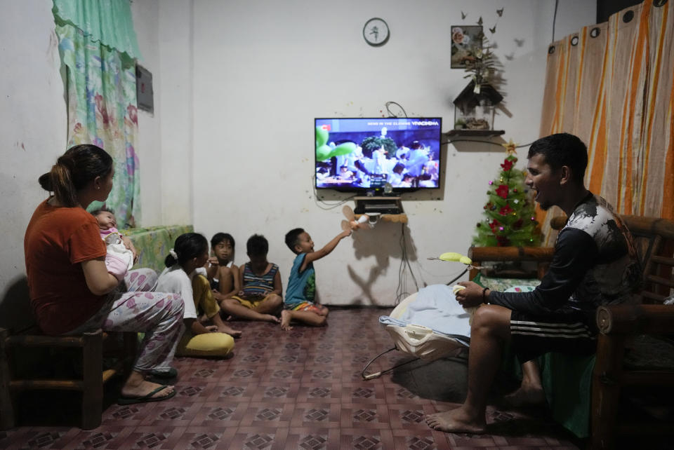 Jeremy Garing, right, and his wife Hyancinth Charm Garing plays with their daughter in their home in a new community for victims of super Typhoon Haiyan in Tacloban, central Philippines on Wednesday, Oct. 26, 2022. Garing and his family settled at a relocation site three years ago after their village was wiped out when the super typhoon struck in 2013, killing six family members and his year-old daughter. (AP Photo/Aaron Favila)