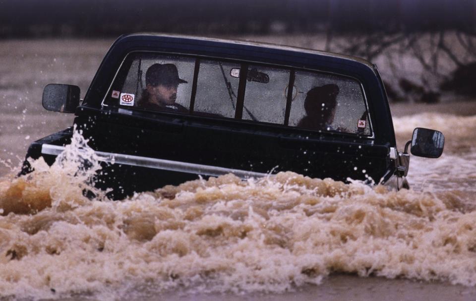 A couple who tried to drive through flood waters near Louisville were forced to try to back out before their truck was submerged. They were barely successful. March 4, 1997.