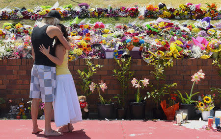 Members of the public react as they leave floral tributes outside the main entrance to Dreamworld located on the Gold Coast, Australia, October 27, 2016 after Tuesday's tragedy that saw four people killed on the Thunder River Rapids Ride at Australia's biggest theme park. AAP/Dave Hunt/via REUTERS